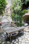 Old wooden table in a Mediterranean courtyard with natural stone floor
