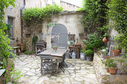 Old wooden table in a Mediterranean courtyard with natural stone floor