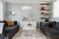 Sofa with scatter cushions and white coffee table in living room with light grey walls