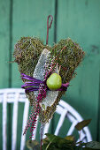 Homemade decorative plug: moss heart with budding heather, leaf of woolly zest, and green apples