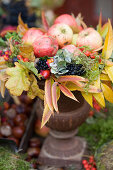 Apples in a colorful autumn wreath of autumn leaves and berries