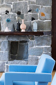 Light blue designer armchair in front of stone wall in living room