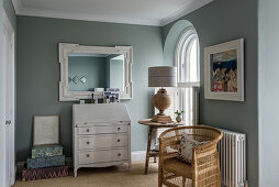 White bureau, mirror, side table and rattan armchair in the anteroom