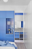 Blue wardrobe in the bedroom, view into the bathroom