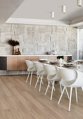 Modern chairs at long dining table in luxurious dining room decorated in beige
