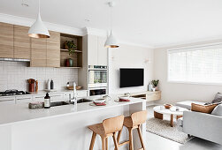 Modern interior decorated in white and beige with open-plan kitchen area