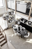 Luxurious, open-plan interior with gallery level and spherical lampshades