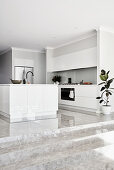Steps leading up to white, modern, minimalist, open-plan kitchen