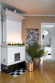 White tiled stove and fir tree in corner of room