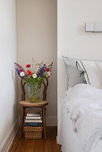 Colorful bouquet of flowers on a chair next to the bed