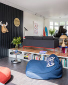 Offener Wohnraum mit dunkler Holzverkleidung im Split-Level-Haus, Sitzsack im Vordergrund