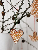 Decorated gingerbread shapes hanging from branch