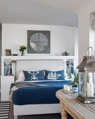 Nautical themed penthouse bedroom with upholstered headboard, cushions and blinds