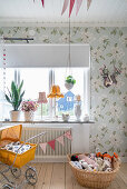 Vintage decorations in vintage-style child's bedroom with floral wallpaper