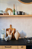 Hand-glazed back splash tiles and shelving above a kitchenette