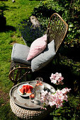 Rattan chair with cushions next to tray of melon in garden