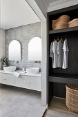 Washstand with twin countertop sinks and walk-in wardrobe in foreground
