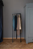 Clothes rack next to grey-blue wardrobe in hallway