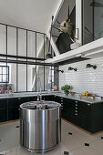 Round kitchen sink, kitchen units with black fronts and marble worktop, subway tiles and interior windows