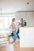 Two friends standing at the kitchen counter in the open-plan interior