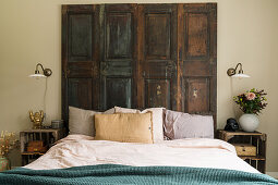 Doppelbett mit alten Holztüren als Betthaupt und Obstkisten als Nachttisch