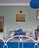 Blue beaded chandelier in bedroom with wrought iron bed