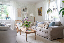 Cosy living room with sofas, grandfather clock and pale wallpaper