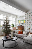 Runder Couchtisch, Weihnachtsbaum, Polstersofa und Sekretär im Wohnzimmer mit Tapete