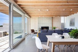 Offener Wohnraum mit Esstisch und Sofa im modernen Architektenhaus