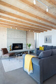 Grey velvet sofa in modern living room with concrete fireplace