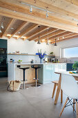 Modern kitchen in open-plan interior with wooden ceiling