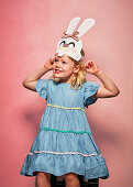 Blonde girl with paper Easter bunnies as head decoration