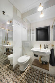 Small bathroom with patterned floor tiles, marble walls and floor-to-ceiling mirror