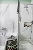 Bath and shower in bathroom with marble-effect tiles