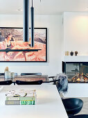 View over kitchen island to dining table and large photo on wall