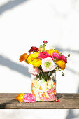 Ranunculus in glass vase, wrapped with wrapping paper