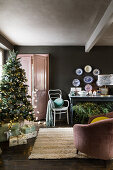 Decorated Christmas tree in the living room; console table and wall plates in the background