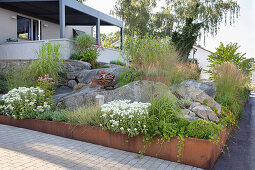 Planted bed with rocks and weathered steel edging