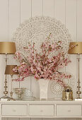 Branches of cherry blossom in vase and silver ornaments