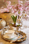 Silbertablett mit Tasse und Hyazinthe in Sauciere, im Hintergrund Kirschblüten