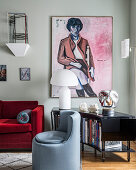 Rotes Samtsofa, großformatiges Kunstwerk über Bücherregal in eklektisch eingerichtetem Wohnzimmer