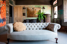 Grey, capitone sofa in rustic room