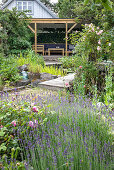 Flowering lavender in the garden, covered wooden terrace in the background