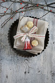 Baking dish with dish towel tied with ribbon and an ornament topped with cookies
