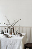 Easter table set with ceramic tableware and naturally coloured Easter eggs