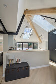 Bright, open plan living room with skylight and staircase
