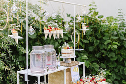 Party buffet with lemonade, naked cake, and snack bags in the garden