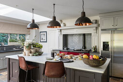 Custom made kitchen island, industrial style pendant lights above in open plan kitchen