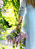 Woman holding bouquet of lilacs