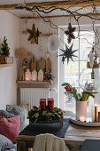 Christmas decoration with Advent wreath, bouquet of flowers, and hanging stars in the dining room